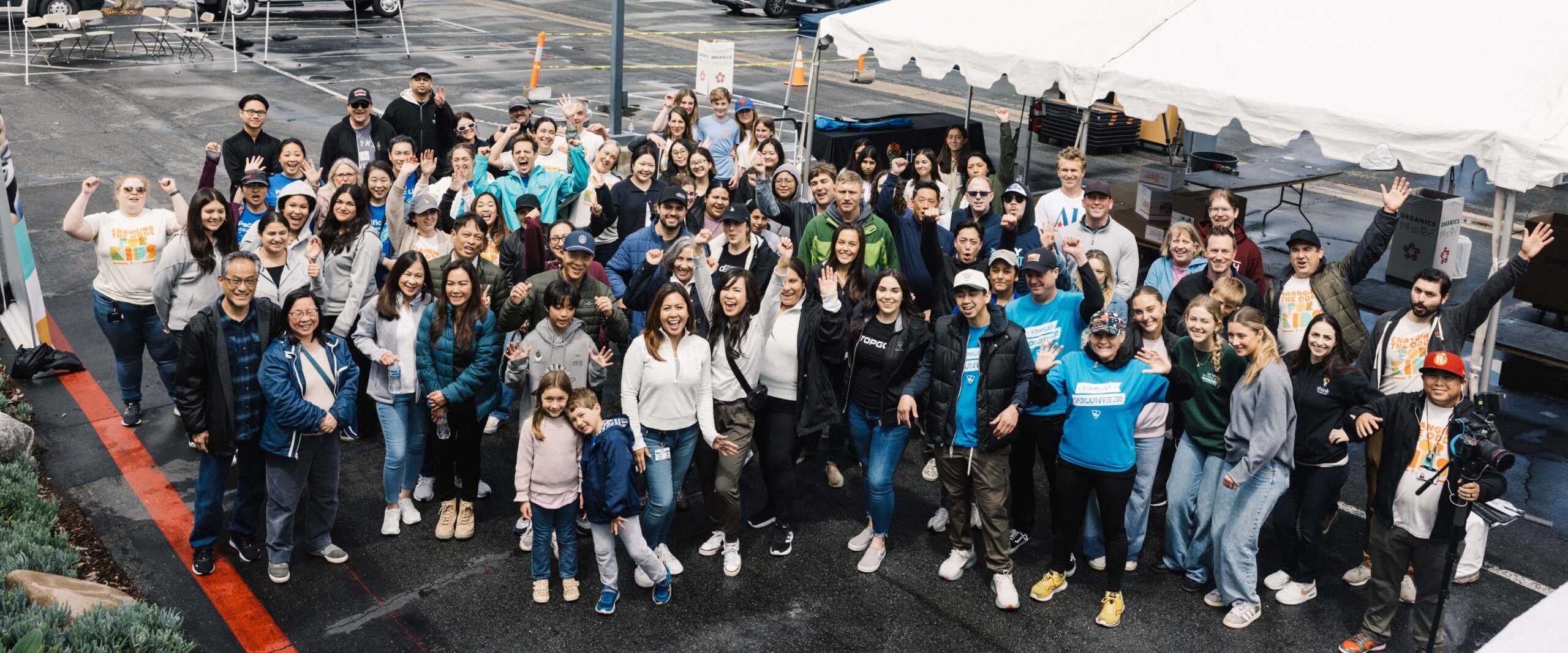 Large group of Think Together volunteers gathered outdoors celebrating a community service event.